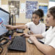 Middle school students work at computer in classroom