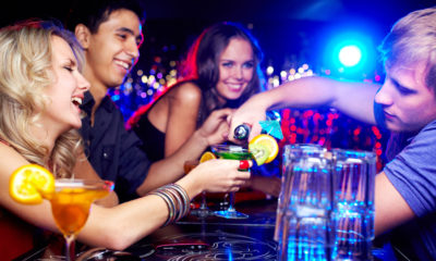 Picture of young adults drinking cocktails at a bar.