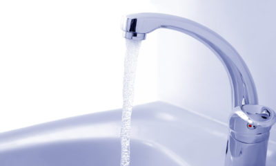 Water pours into a sink from a faucet