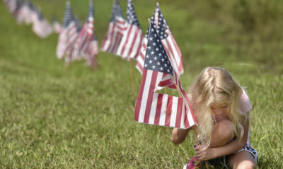 AP photo of a young girl putting American flags into the ground