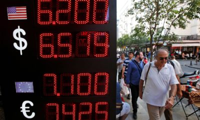 Photo of people walking past a currency exchange shop in Istanbul