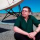 File Photo of Art Bell siting near a satellite in Nevada