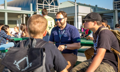 Photo of two students sitting outside with a teacher at CTEC