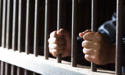 Closeup photo of man's hands isolated in jail