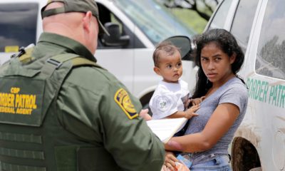 Photo of a mother and her child surrendering to U.S. Border Patrol agents