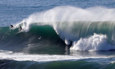 Photo of two surfers sharing a wave in Half Moon Bay, California