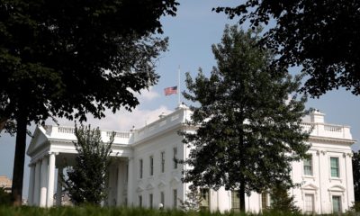 Photo of the American flag flying half-staff at the White House in Washington