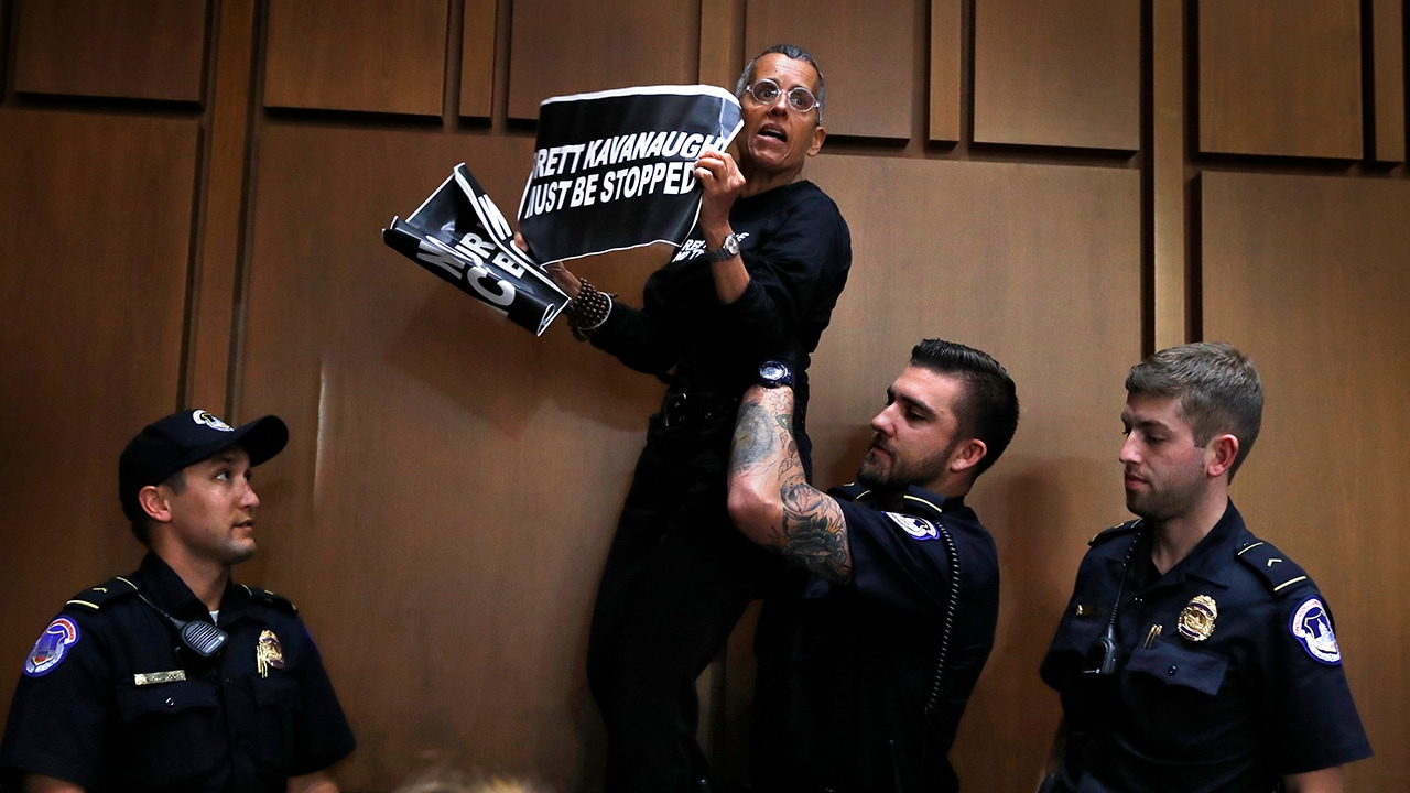 A protester is lifted off of a chair by U.S. Capitol Police