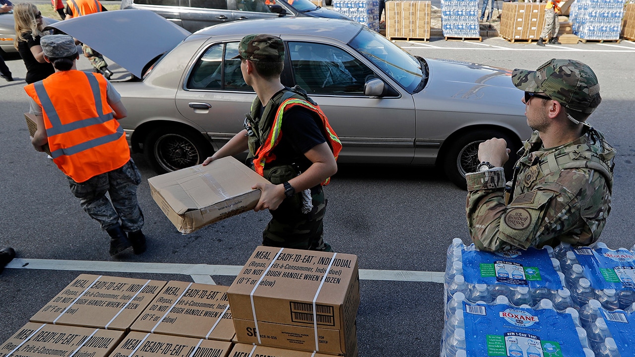 Photo of members of the Civil Air Patrol loading cars with MREs, water and tarps