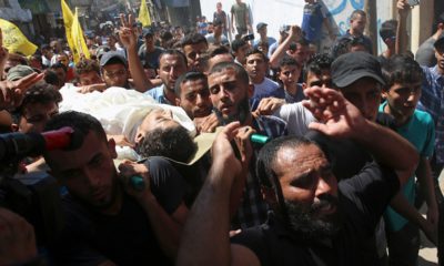 Photo of mourners chanting while carrying the body of Ahamd Omar