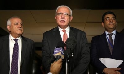 Photo of Riyad al-Maliki speaking to reporters