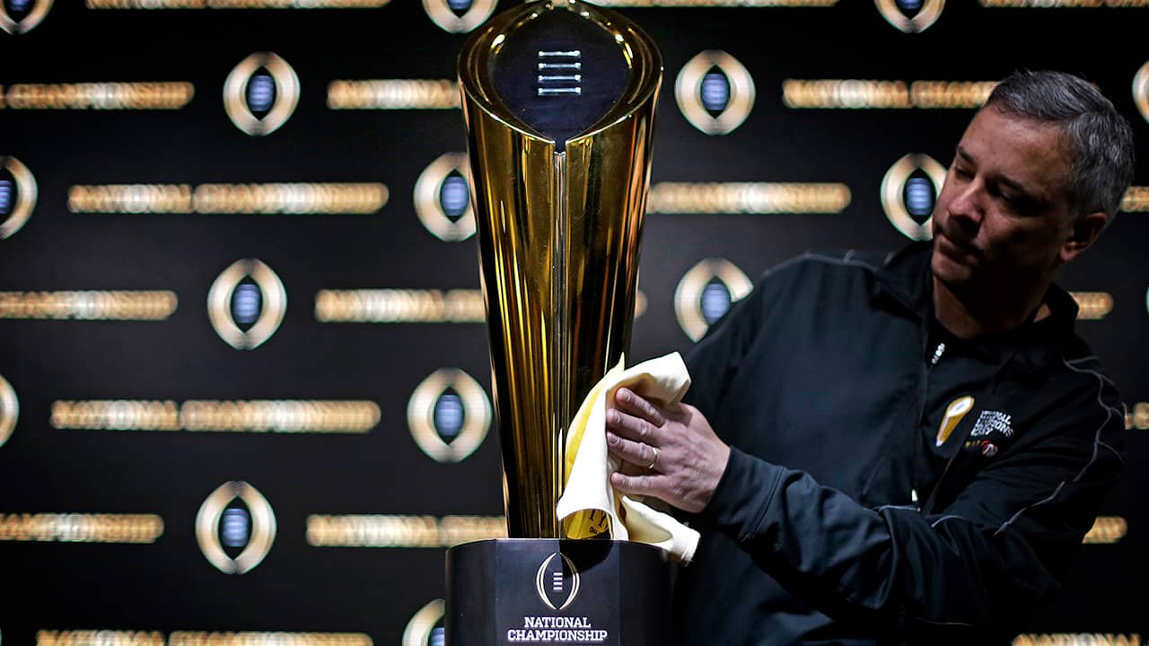 Photo of Charley Green buffing the NCAA college football championship trophy
