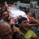 Photo of mourners carrying the body of Palestinian Naji Zaanin, 25