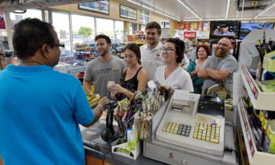 Photo of people lining up at a store to buy lottery tickets