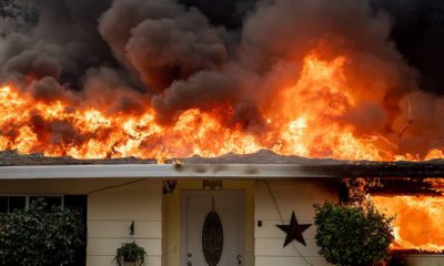 Photo of a home burning in Paradise, California.