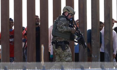 Photo of Border Protection officers walking along a wall at the border between Mexico and the U.S.