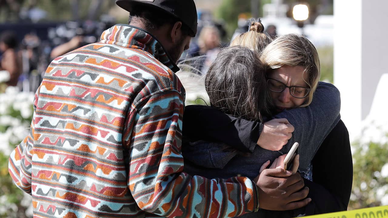 Photo of mourners embracing out side of the Thousand Oaks Teen Center