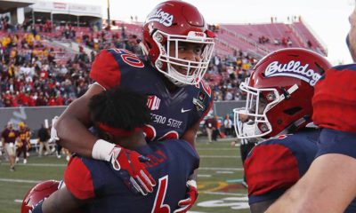 Photo of Fresno State defensive back Anthoula Kelly holding up game MVP running back Ronnie Rivers
