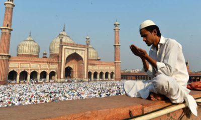 A Muslim offers prayers outside of a mosque.