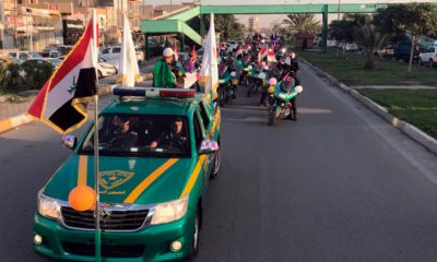Photo of Iraqi security forces raising national flags in a parade