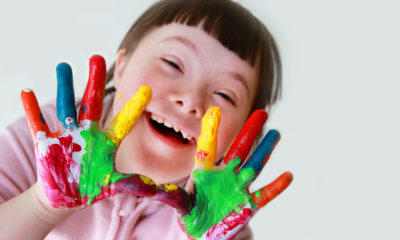 Photo of young girl with down syndrome showing off her painted hands