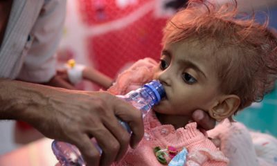 Photo of a father giving his daughter water