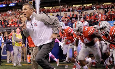 Photo of Urban Meyer running onto the field with his team