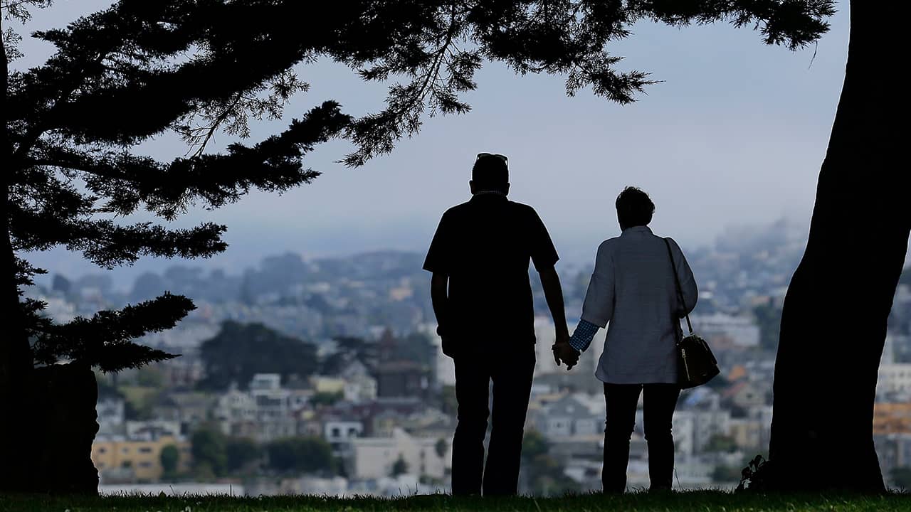 Photo of a man and woman walking under trees in San Francisco