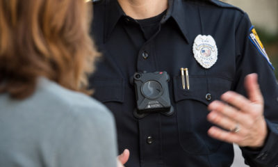 Photo of an officer with a body cam talking to a woman