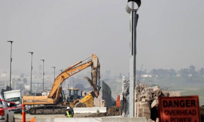 Photo of crews working to demolish border wall prototypes