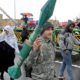 Photo of teenager carrying a mock rocket propelled grenade