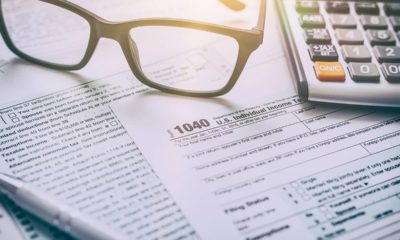 Photo of tax form, glasses, and a calculator