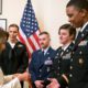 Photo of Nancy Pelosi giving challenge coins to military service members