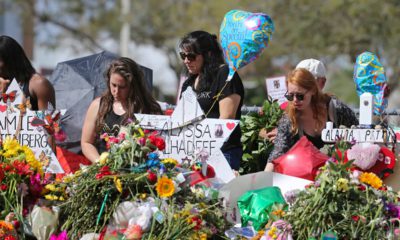 Photo of mourners paying tribute at a memorial for the victims of the shooting at Marjory Stoneman Douglas High School