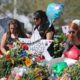 Photo of mourners paying tribute at a memorial for the victims of the shooting at Marjory Stoneman Douglas High School