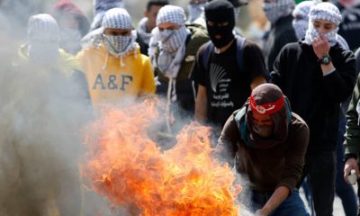 Photo of a Palestinian protester burning a tyre during clashes with Israeli troops