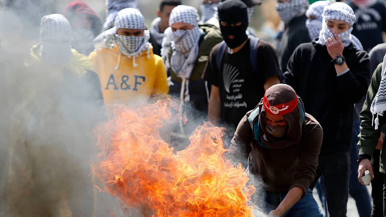 Photo of a Palestinian protester burning a tyre during clashes with Israeli troops