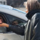 Photo of a woman receiving money from a person in a car