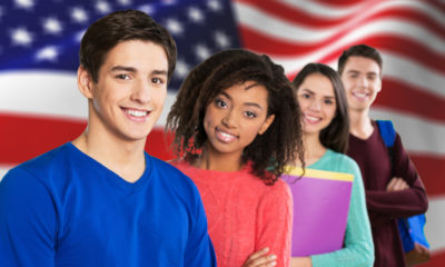 Photo of students posing in front of an American flag