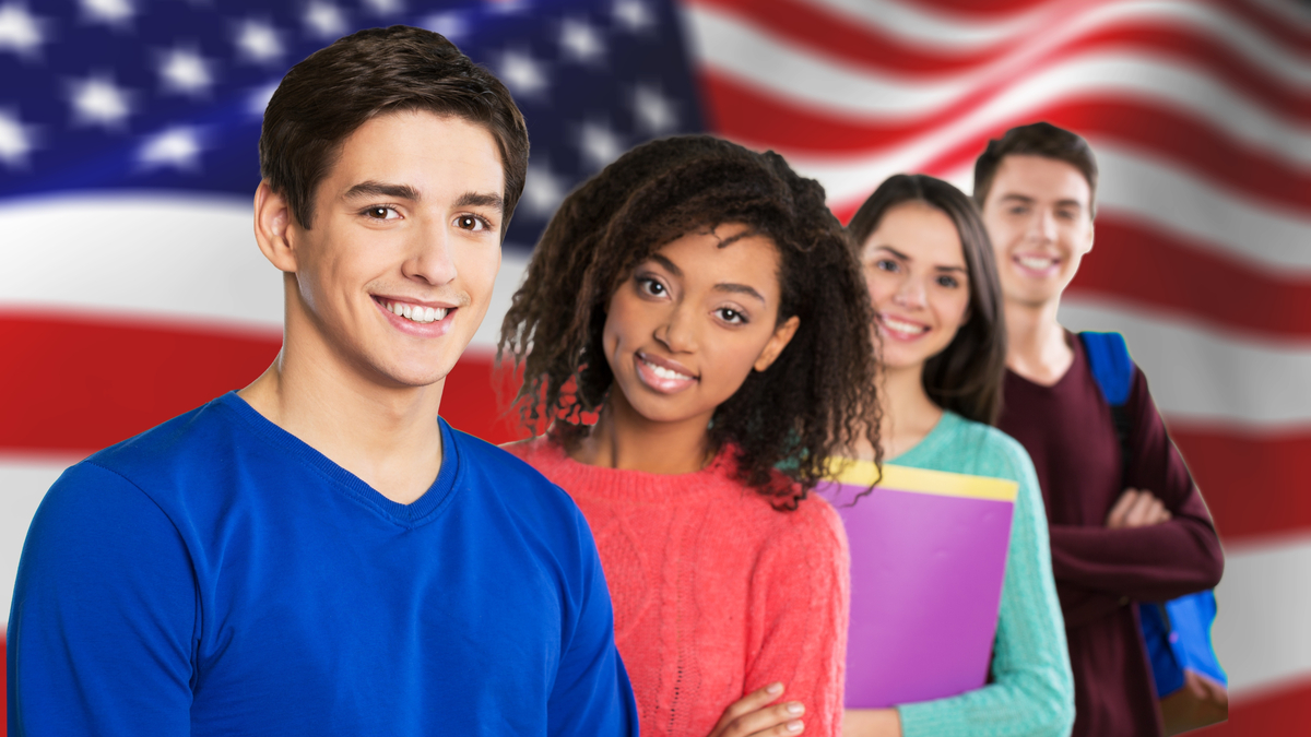 Photo of students posing in front of an American flag