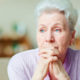Older woman gazes off into the distance.