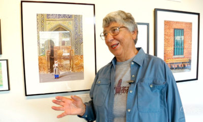 Photographer Helen Gigliotti stands next to a photo from her trip to Iran.