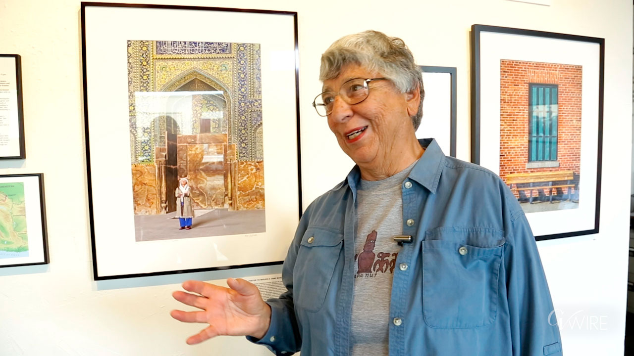 Photographer Helen Gigliotti stands next to a photo from her trip to Iran.