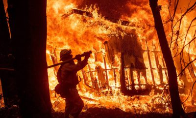 Photo of firefighter Jose Corona spraying water at flames