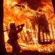 Photo of firefighter Jose Corona spraying water at flames