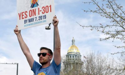 Photo of Chris Olson holding a sign in Denver