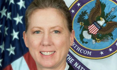 Photo of Brig. Gen. Laura Yeager in front of an American flag and military emblem