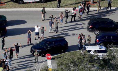 Photo of students holding their hands in the air as they are evacuated in Parkland, Fla.