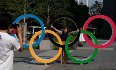 Photo of Tokyo resident taking a picture of his wife with the Olympic rings in Tokyo