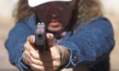 Photo of school secretary aiming a pistol at a shooting range